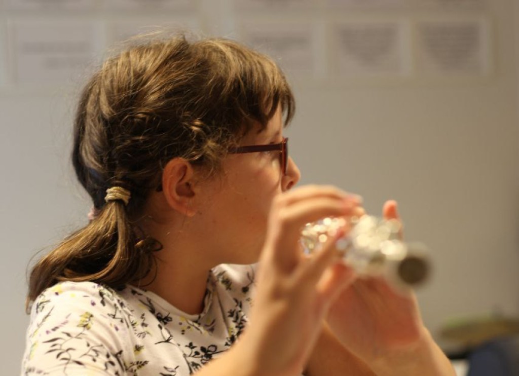 Ein Mädchen spielt Querflöte.