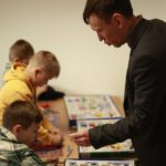 Преподаватель передаёт ученику деталь, пока группа выполняет эксперимент.