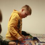 Мальчик в жёлтом худи собирает электронный набор со снап-схемами