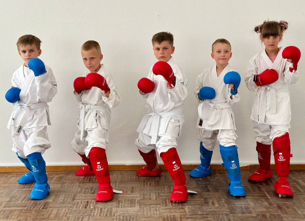 Fünf Kinder mit roten und blauen Schützern in Kampfhaltung.
