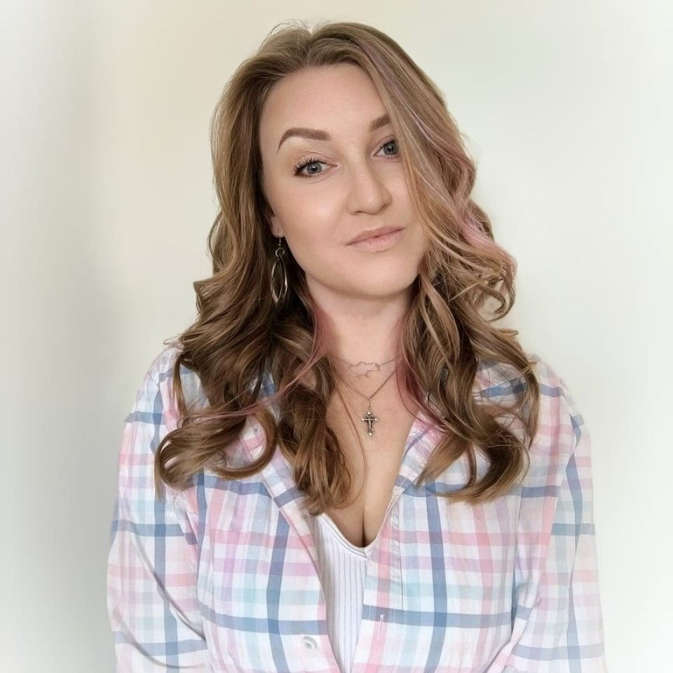 Eine Frau in einem karierten Hemd mit langen blonden Haaren.