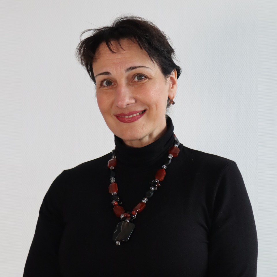 Die Frau im schwarzen Pullover lächelt.