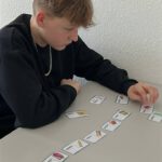 Подросток выстраивает цепочку карточек со словами, повторяя лексику по русскому.