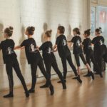 Дети выполняют классические упражнения у балетного станка.