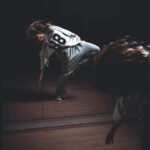 Танцовщица выразительно двигается перед зеркалом.