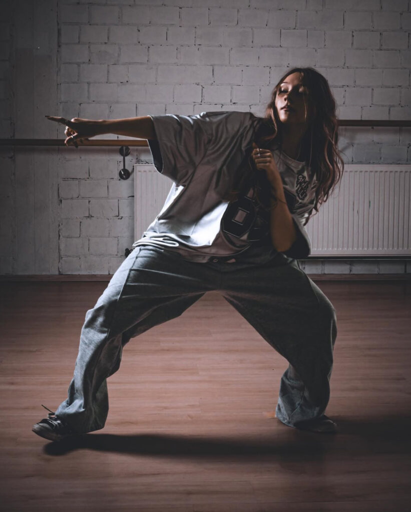 Tänzerin in dynamischer Pose während des Hip-Hop-Trainings.