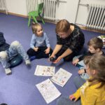 Игра со звуками и буквами: группа на ковре выполняет задания по русскому языку.