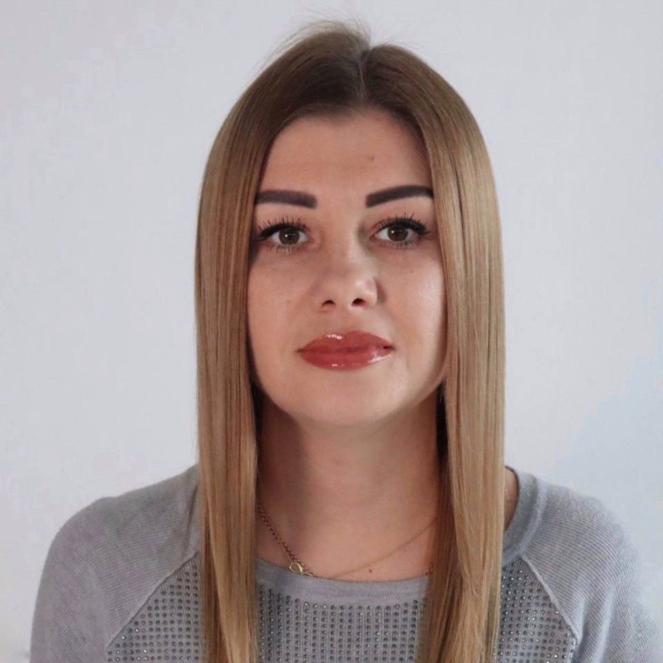 Frau mit langen blonden Haaren schaut in die Kamera